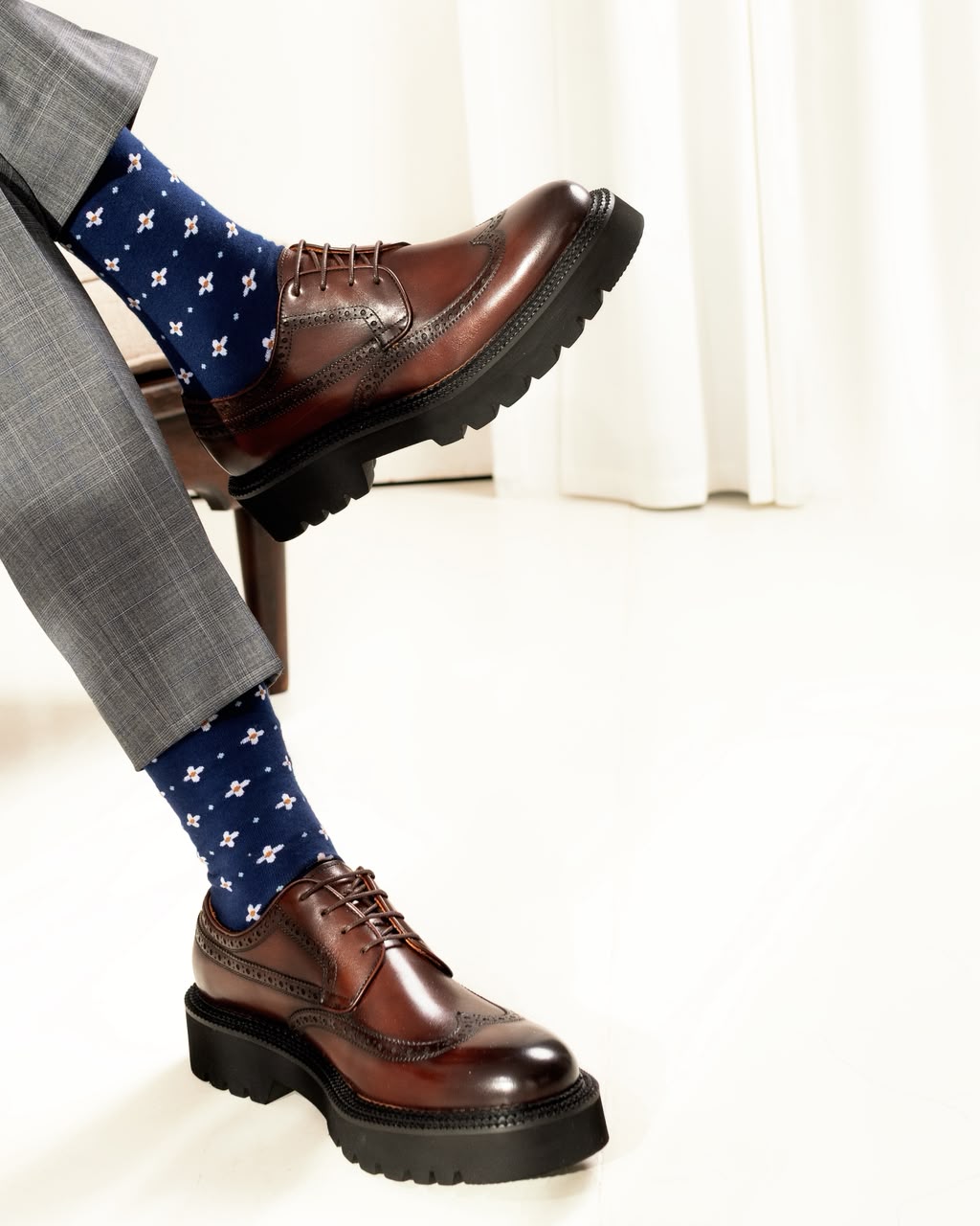 A pair of chestnut leather derby shoes photographed in studio light